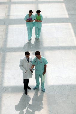 Hospital staff walking down corridor clipart