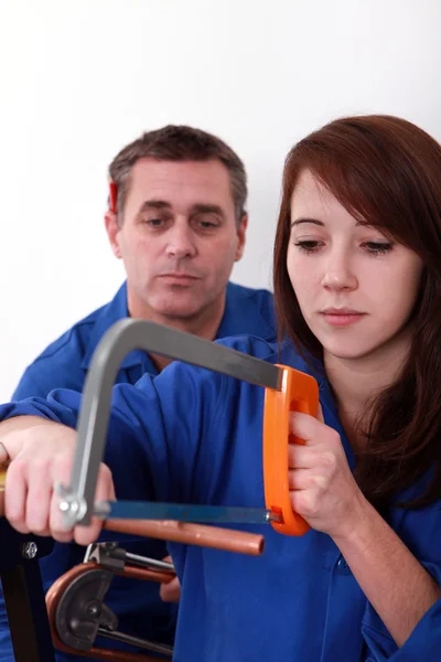 Young apprentice sawing copper pipe — Stock Photo, Image