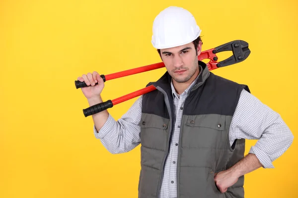 Tradesman carrying a pair of large clippers on his shoulder — Stock Photo, Image