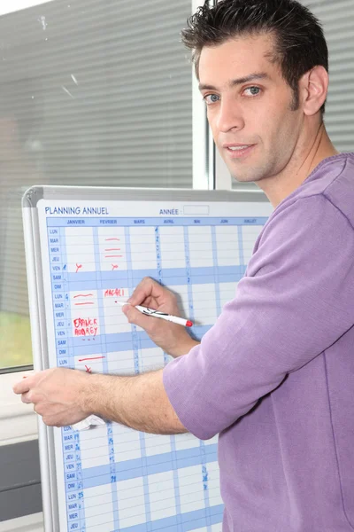 Homem escrevendo em um planejador de quadro branco — Fotografia de Stock