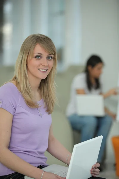 Junge Frau sitzt mit Laptop auf dem Schoß — Stockfoto