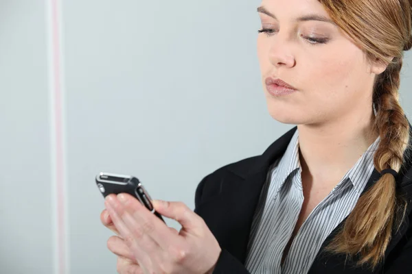 Junge Geschäftsfrau checkt Telefon. — Stockfoto