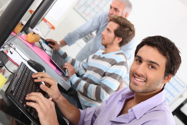 Uśmiechnięty mężczyzna młody za pomocą komputera — Zdjęcie stockowe
