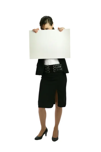 Businesswoman hiding behind an ad board — Stock Photo, Image
