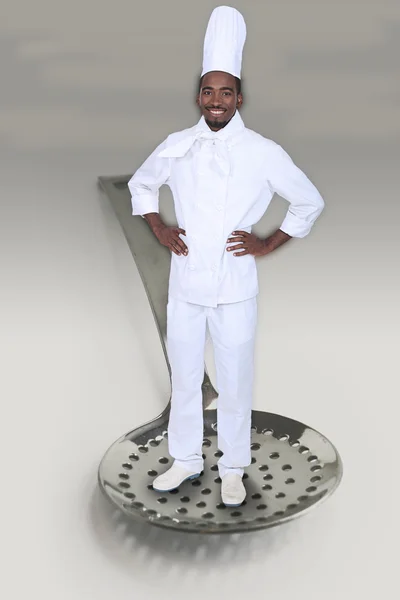 Fotomontagem de um cozinheiro de pé em um coador — Fotografia de Stock