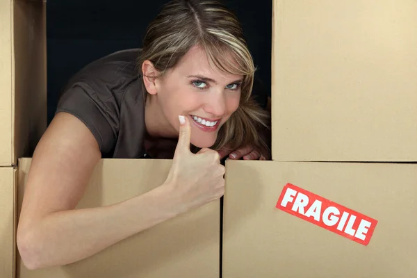 Mujer parada entre frágiles cajas — Foto de Stock