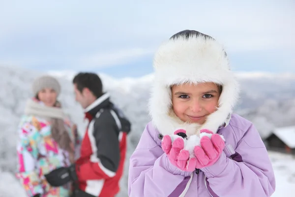 小さな女の子が彼女の両親と雪で遊んで — ストック写真