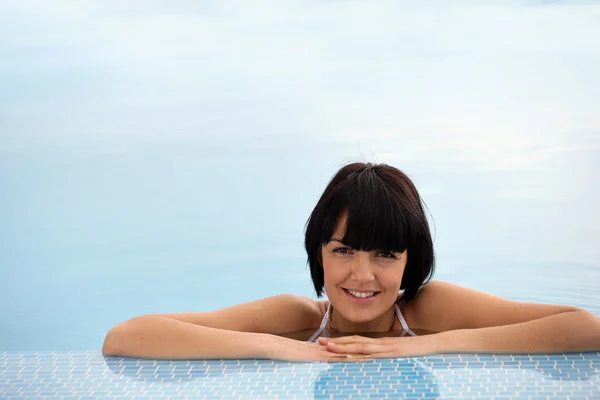 Woman relaxing in a swimming pool — Stock Photo, Image