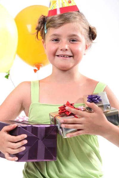 Little girl at birthday party with lots of gifts — Stock Photo, Image
