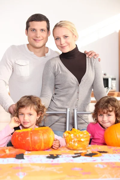 Familia reunida alrededor de la mesa de la cocina preparando calabazas —  Fotos de Stock