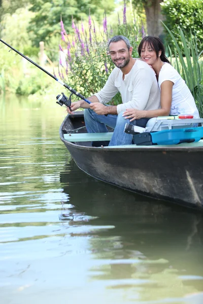 Casal de pesca em um barco em um rio — Fotografia de Stock