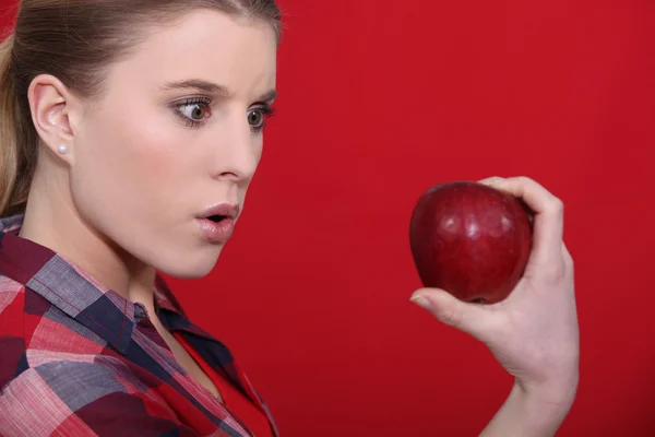 Mulher chocada segurando maçã — Fotografia de Stock