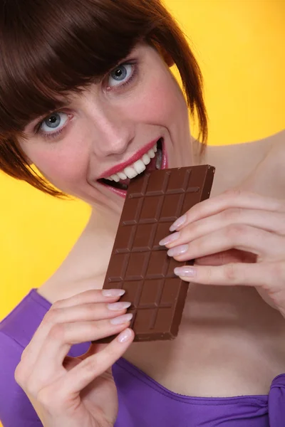 Femme mangeant des barres de chocolat — Photo