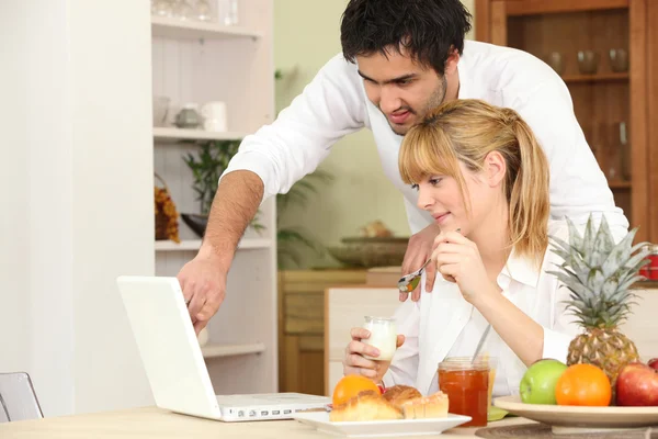 ノート パソコンの前に朝食を食べるカップル — ストック写真