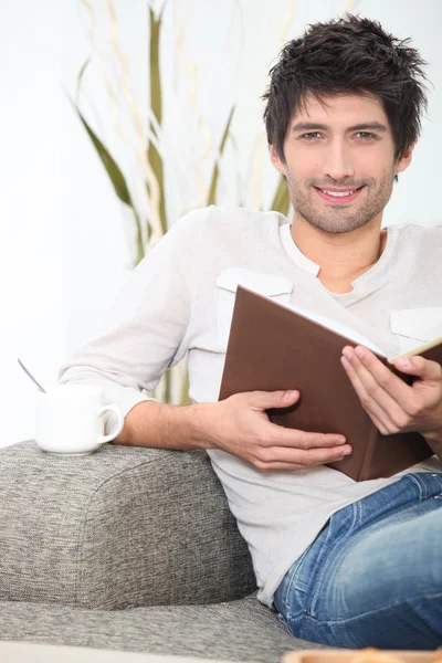Mannen satt läsning på soffa — Stockfoto