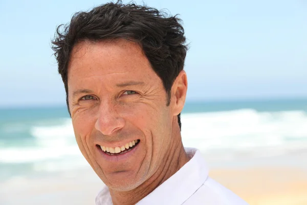 Man smiling at the seaside. — Stock Photo, Image