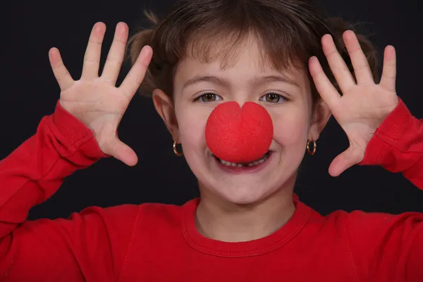 Liten flicka med röd näsa spela clown — Stockfoto