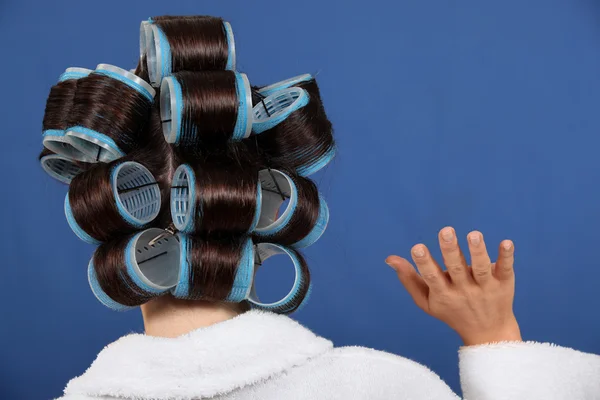 Back view of a woman wearing rollers and waving — Stock Photo, Image