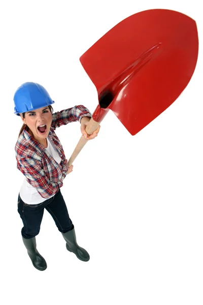 Expressive tradeswoman holding up a spade — Stock Photo, Image