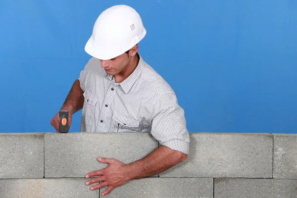 Hombre enderezando pared de ladrillo — Foto de Stock