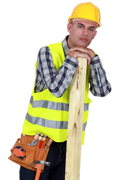 Un falegname appoggiato uno un pezzo di legno . — Foto Stock