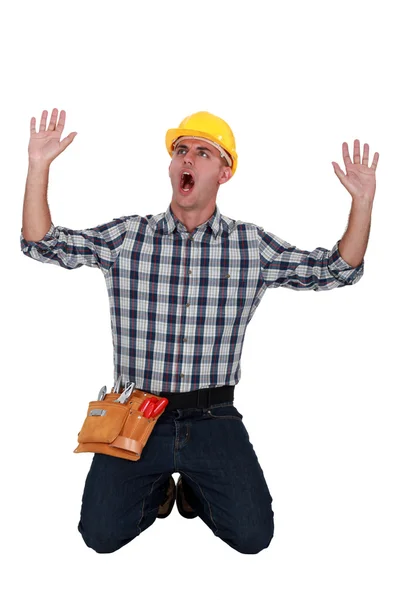 Craftsman on his knees raising hands and shouting — Stock Photo, Image