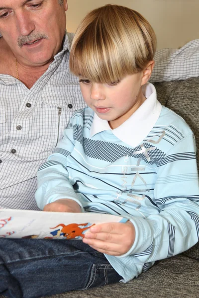 Man die een boek leest aan een kleine jongen — Stockfoto