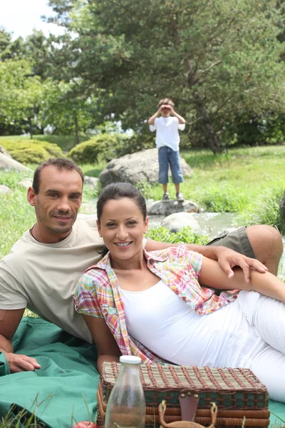 Família desfrutando de um piquenique no campo — Fotografia de Stock