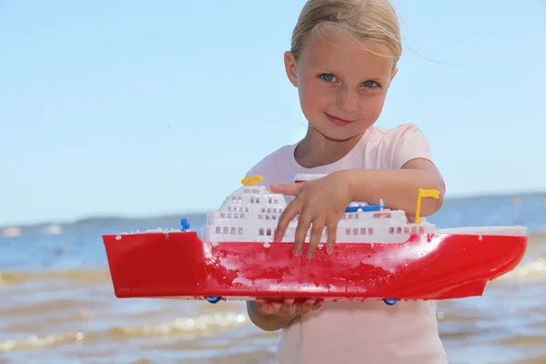 Girl playing with toy boat — Stock Photo, Image