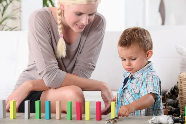 Moeder en zoon spelen met domino's — Stockfoto