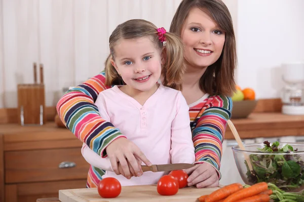 母亲和女儿切片西红柿 — 图库照片