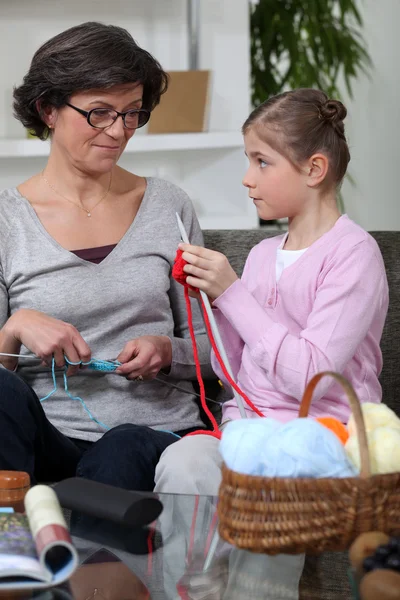 Little girl and grandmother knitting together — Stock Photo, Image