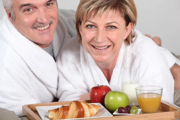 Paar frühstückt im Bett — Stockfoto