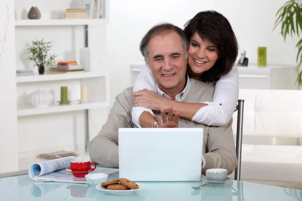 夫妇在其笔记本电脑前微笑 — 图库照片