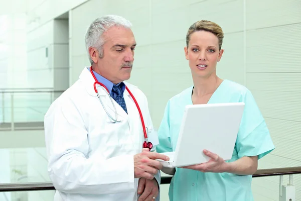 Arts en verpleegkundige op zoek naar een laptop — Stockfoto