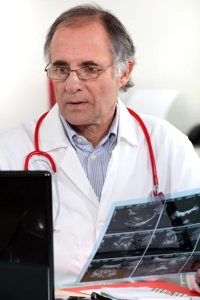 Male doctor examining x-ray — Stock Photo, Image