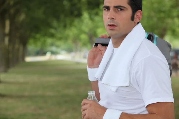 Sportler im Park mit einer Flasche Wasser — Stockfoto
