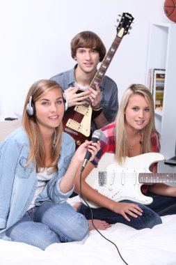 Teenagers making music in a bedroom clipart