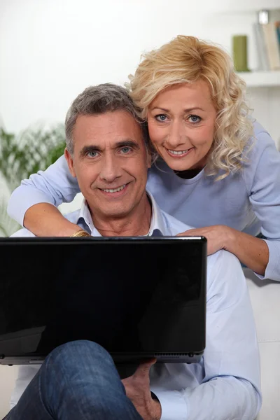 Äldre par med en bärbar dator — Stockfoto