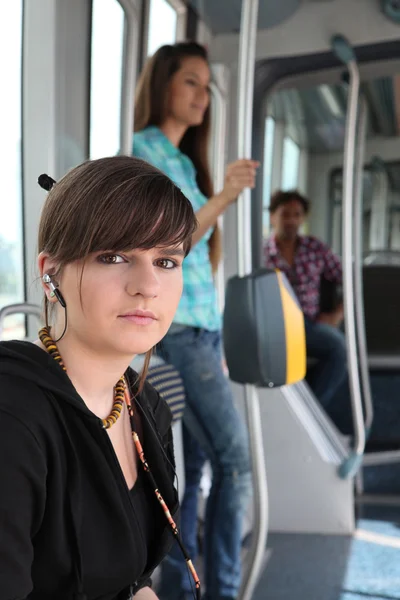 Photo of teenager riding the tram with passenger in background — Stock Photo, Image