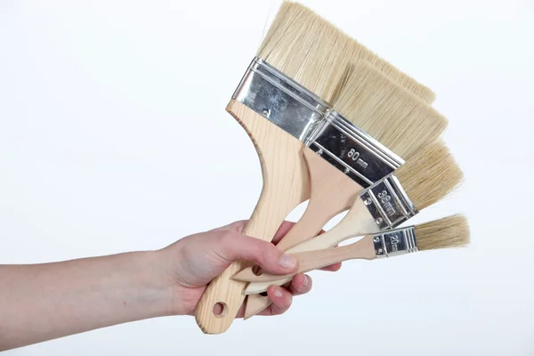 Mano femenina extendiendo cepillos —  Fotos de Stock