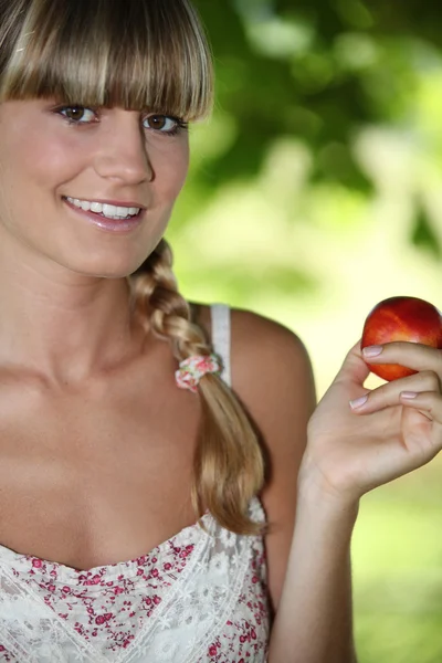 Mujer joven y hermosa sosteniendo una nectarina —  Fotos de Stock