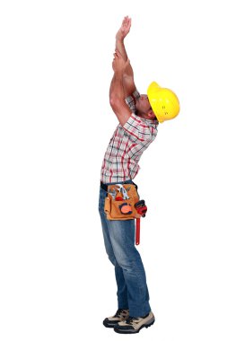 Laborer trying to touch the ceiling, studio shot clipart