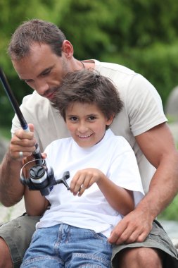 Father and son fishing together clipart