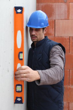 Construction worker using a spirit level clipart