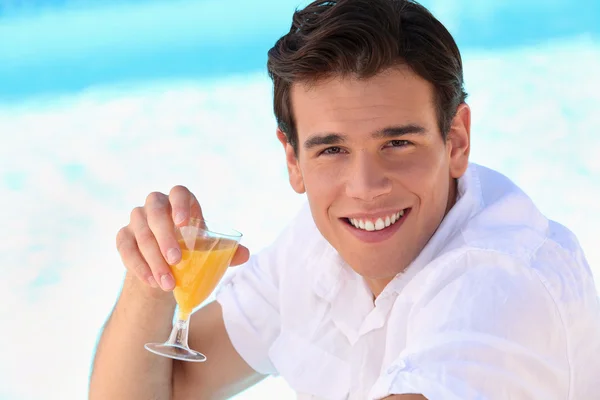 Mladý muž líbí pomerančový džus — Stock fotografie