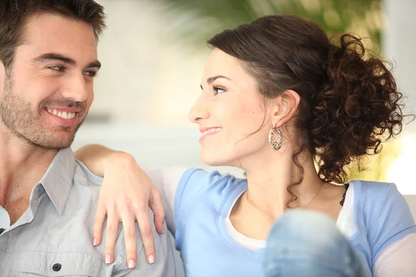 Affectionate young couple on couch — Stock Photo, Image