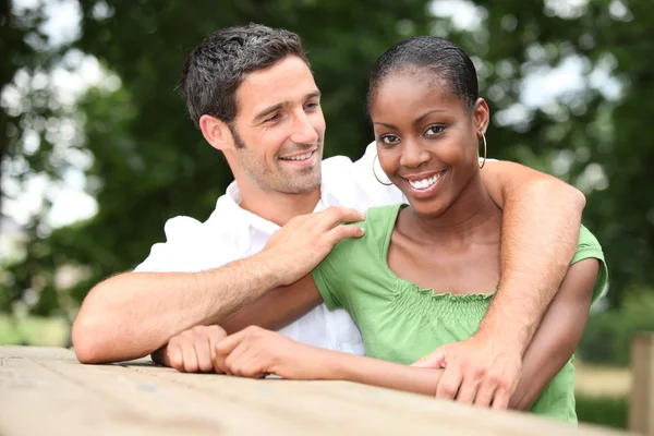 Mixed race couple cuddling in the countryside — Stock Photo, Image