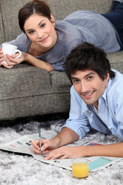 Jornal de leitura de casal em casa — Fotografia de Stock
