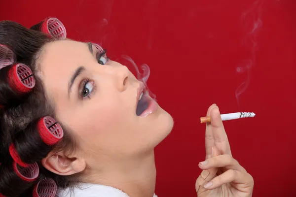 Frau mit Haarrollen beim Rauchen — Stockfoto